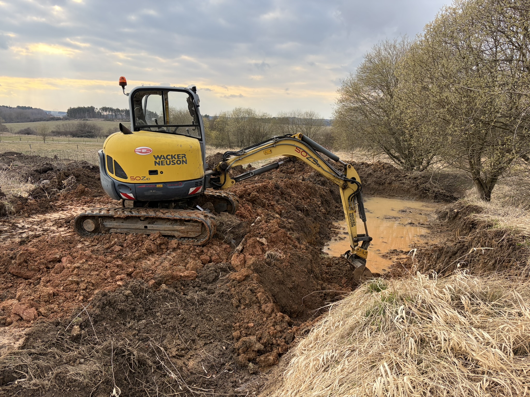 Hloubení rybníku – bagr Wacker Neuson při hloubení